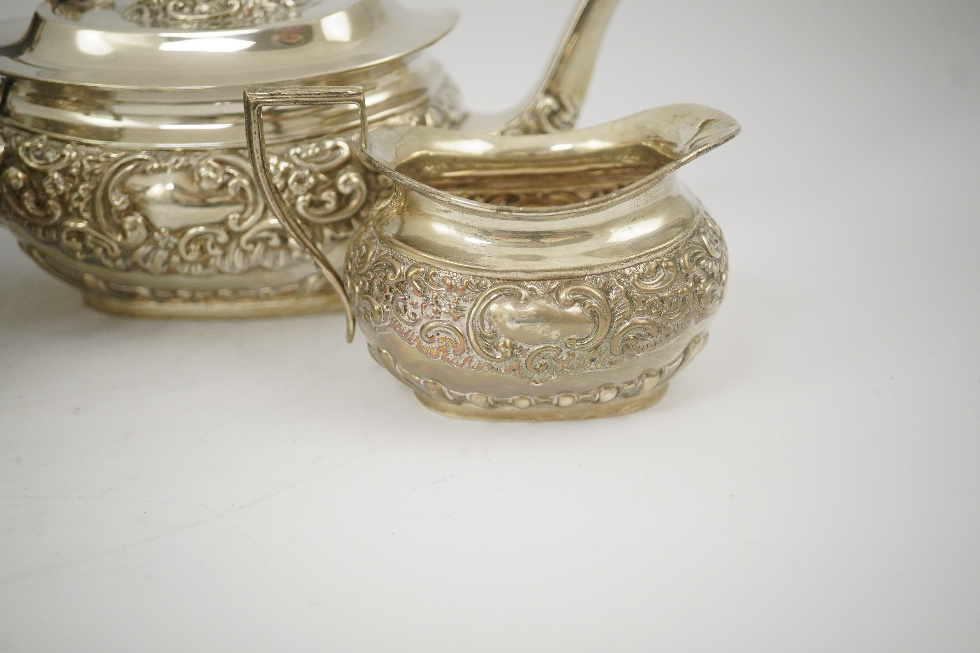 An Edwardian embossed silver four piece tea and coffee set, by S. Glass